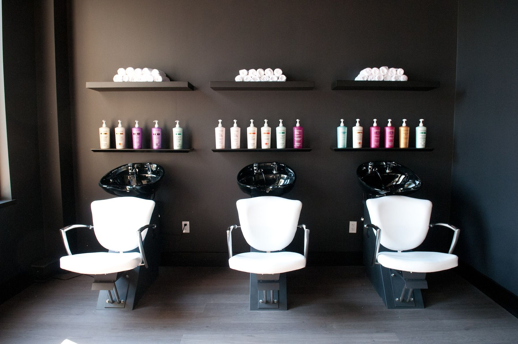 Dark-walled wash station with shampoo bowls